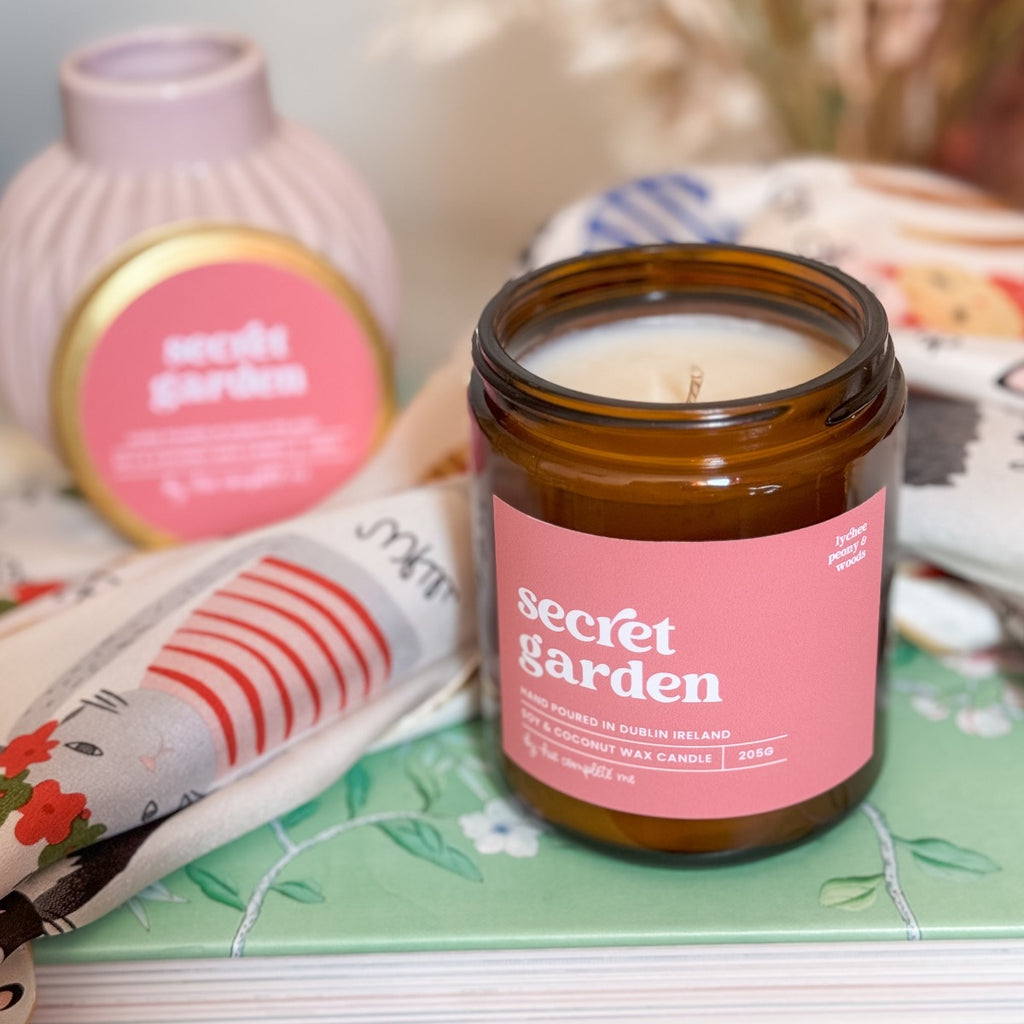 Secret garden lychee peony and woods scented candle. Hand poured in Dublin in an amber glass jar