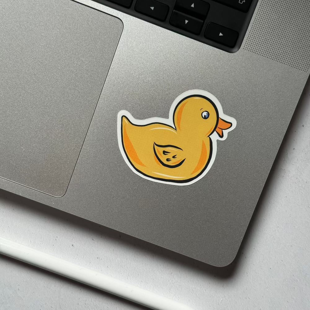 Yellow rubber duck vinyl sticker on a laptop, showcasing its cheerful and playful style for a personalised touch