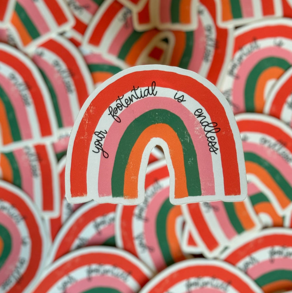 Close-up of a group of 'Your Potential Is Endless' rainbow stickers, showcasing their bright and uplifting message