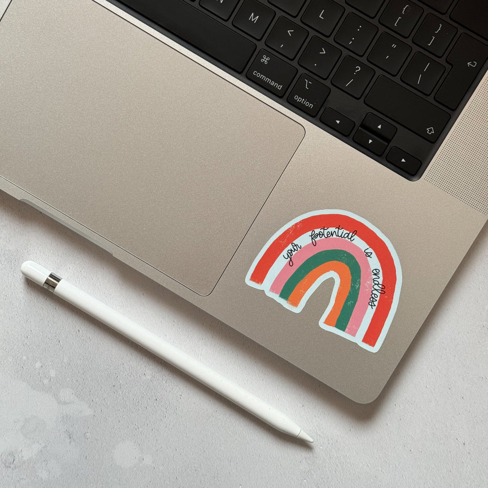 Close-up of the 'Your Potential Is Endless' rainbow sticker on a laptop, bringing a burst of colour and inspiration to your workspace