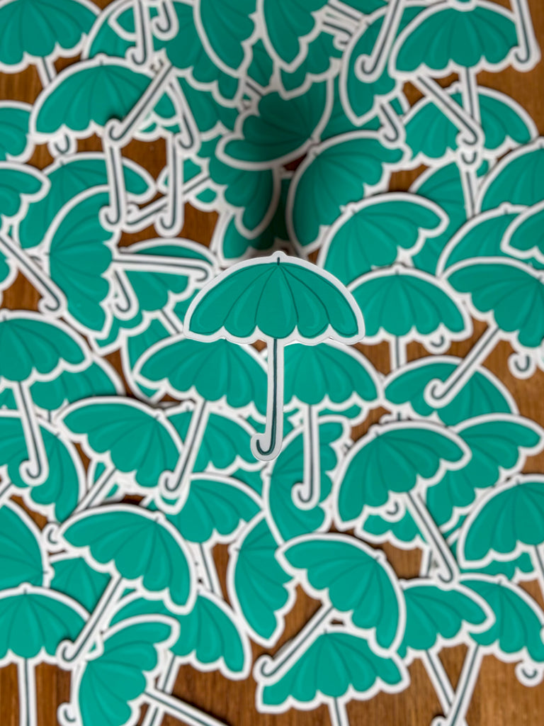 Close-up of a teal umbrella vinyl sticker with a vibrant and colourful design, perfect for personalising items